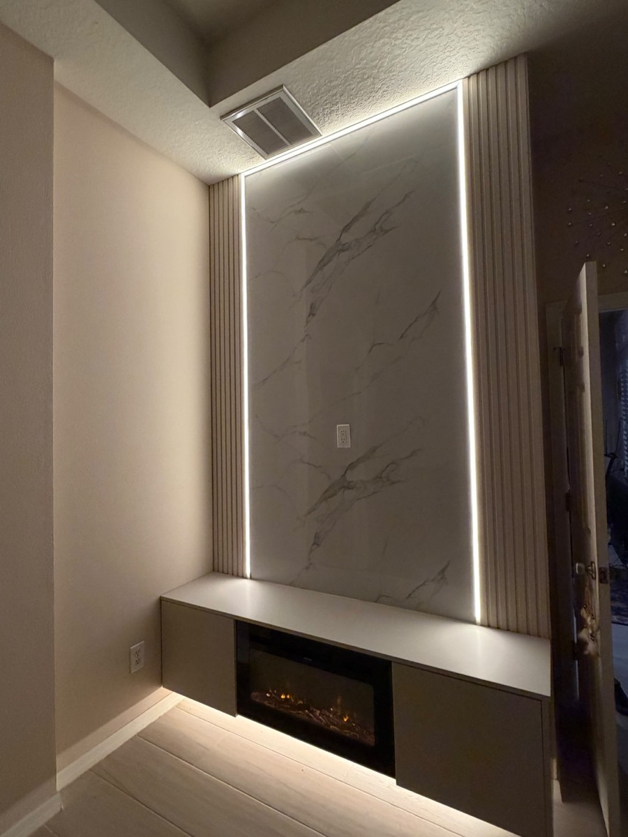 Marble slab media wall with wood slats, LED strips and a built-in fireplace